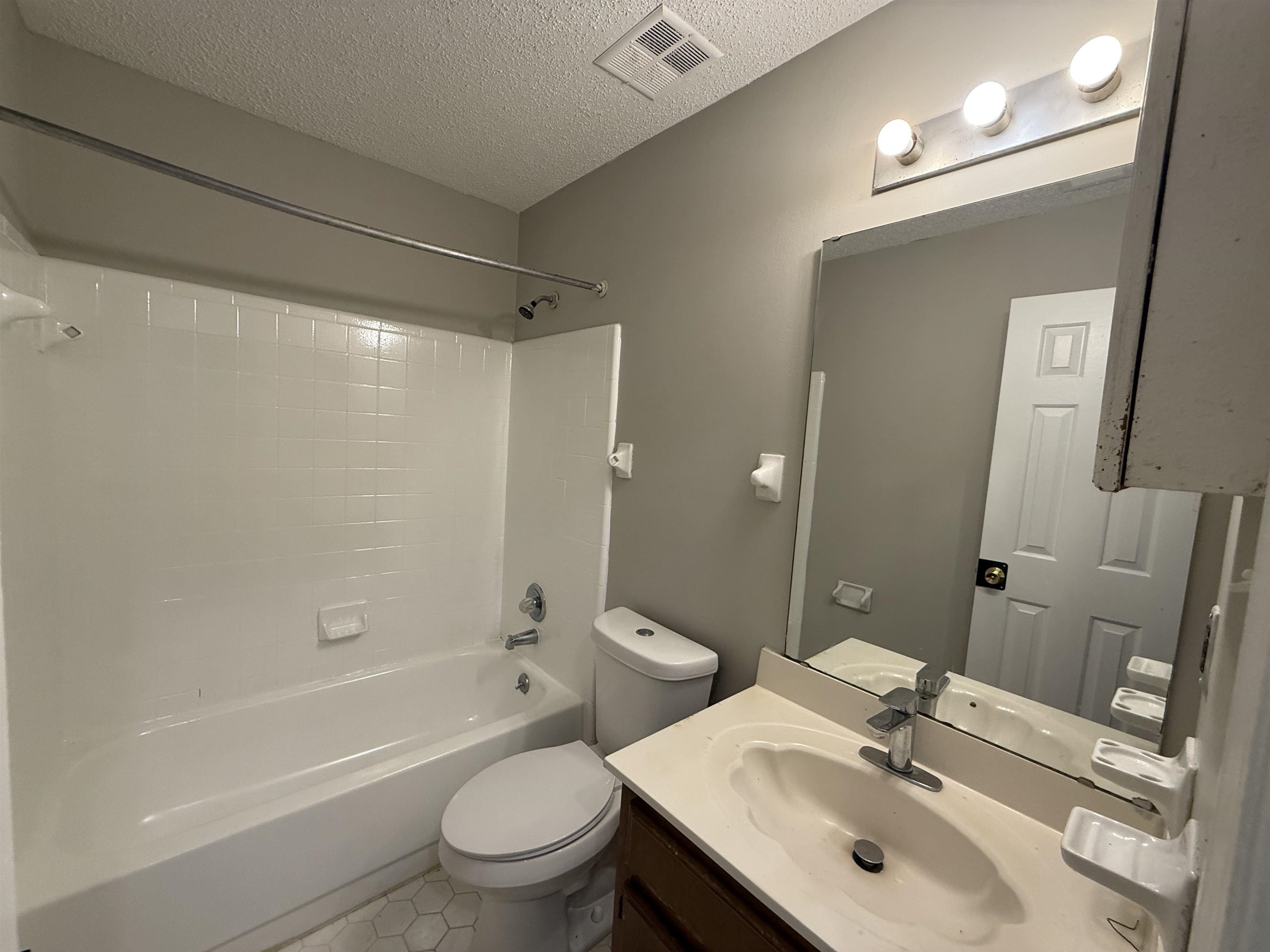 6420 Saginaw Road Memphis, TN 38134 - Photo 23 of 38 Full bathroom featuring a white tub/shower combination with chrome fixtures, a white toilet, and hexagonal floor tiling
