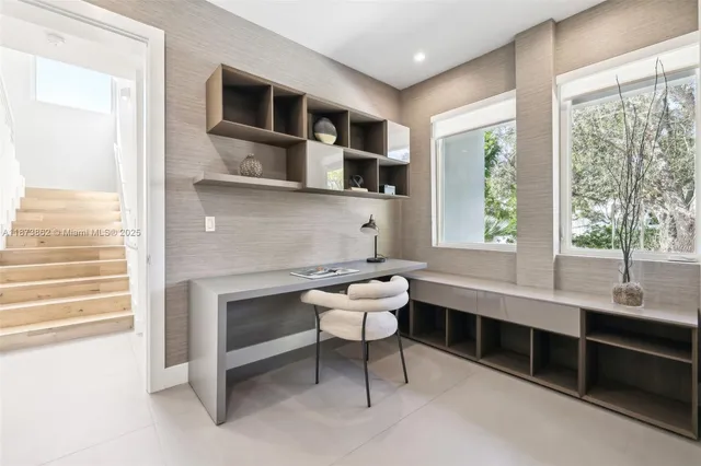 a living room with furniture and large windows