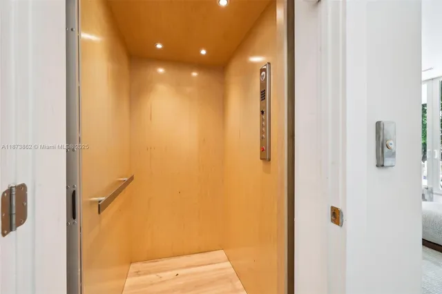 a living room with patio furniture and a chandelier