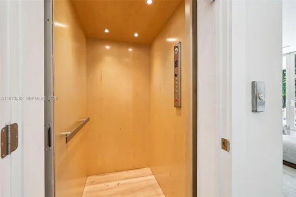 a living room with patio furniture and a chandelier
