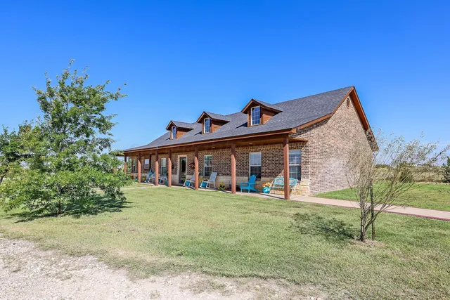 a view of a house with a yard and sitting area