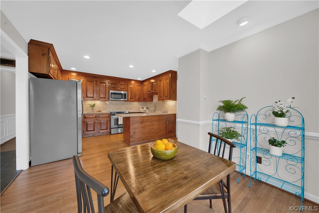 8307 Spring Meadow Road North Chesterfield, VA 23235 - Photo 16 of 47 a kitchen with stainless steel appliances granite countertop a dining table chairs and a refrigerator
