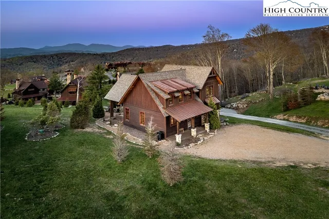 an aerial view of a house with garden space and a car parked on the street