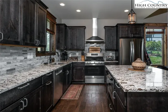 a kitchen with stainless steel appliances wooden cabinets counter space a sink and a stove