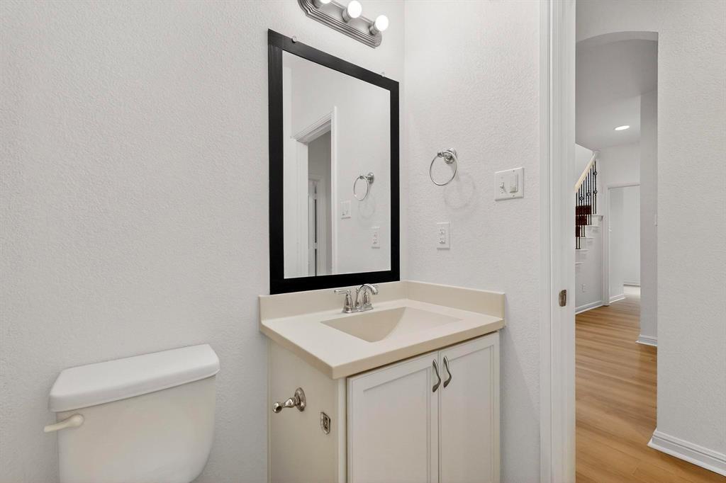 174 Hampton Drive Fate, TX 75087 - Photo 23 of 40 a bathroom with a sink a toilet and mirror
