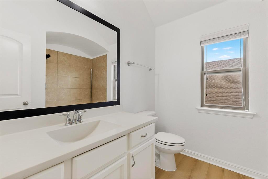 174 Hampton Drive Fate, TX 75087 - Photo 26 of 40 a bathroom with a granite countertop sink toilet and mirror