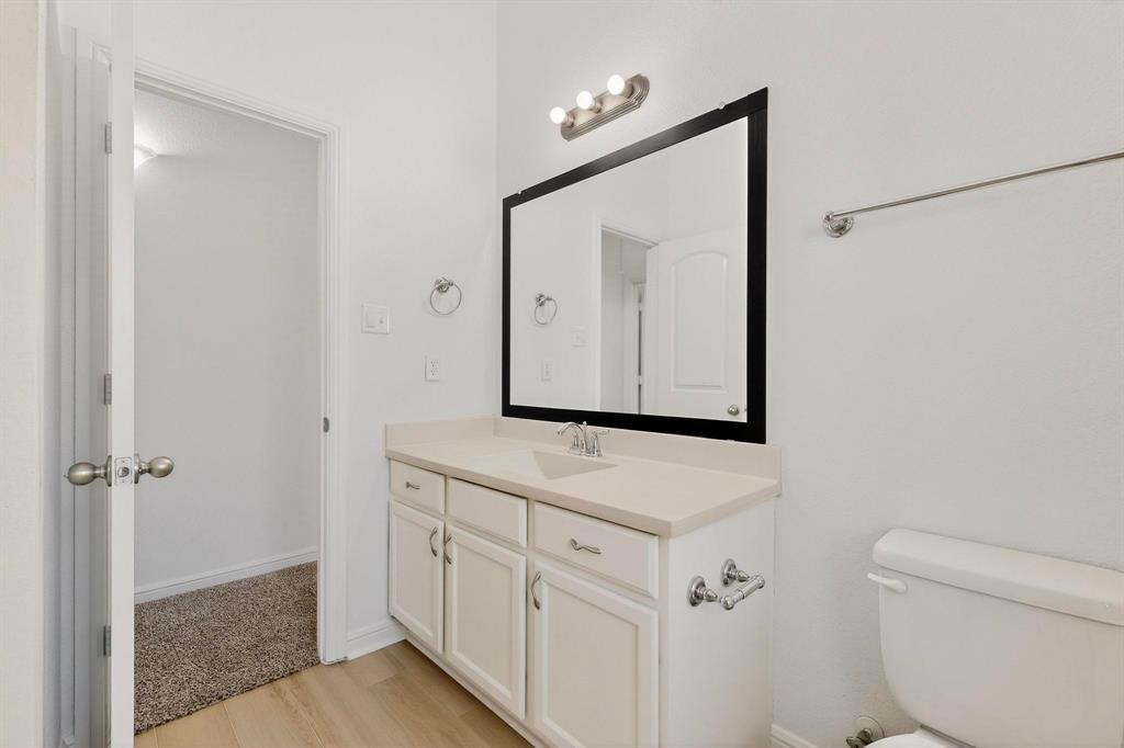 174 Hampton Drive Fate, TX 75087 - Photo 27 of 40 a bathroom with a toilet a sink a vanity and mirror