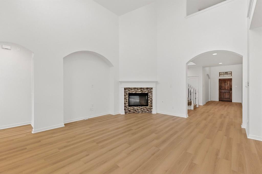 174 Hampton Drive Fate, TX 75087 - Photo 6 of 40 a view of an empty room with wooden floor and a window