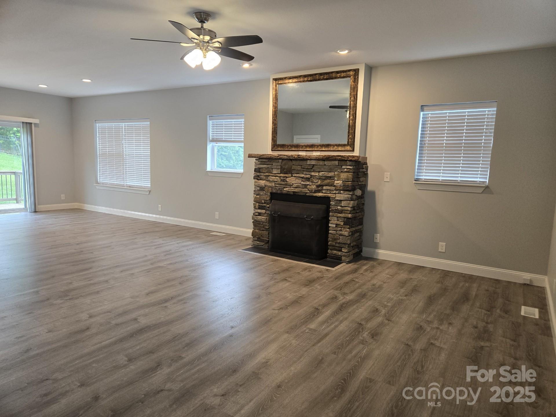 119 Tryon View Drive Flat Rock, NC 28731 - Photo 6 of 22 a view of a livingroom with a fireplace a ceiling fan and wooden floor