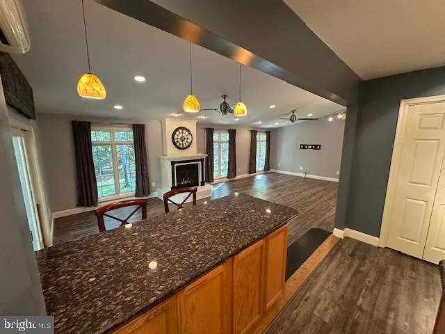 a kitchen with stainless steel appliances granite countertop a stove a sink dishwasher and a microwave oven with wooden floor