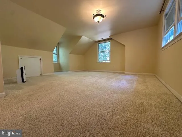 an empty room with windows and fireplace