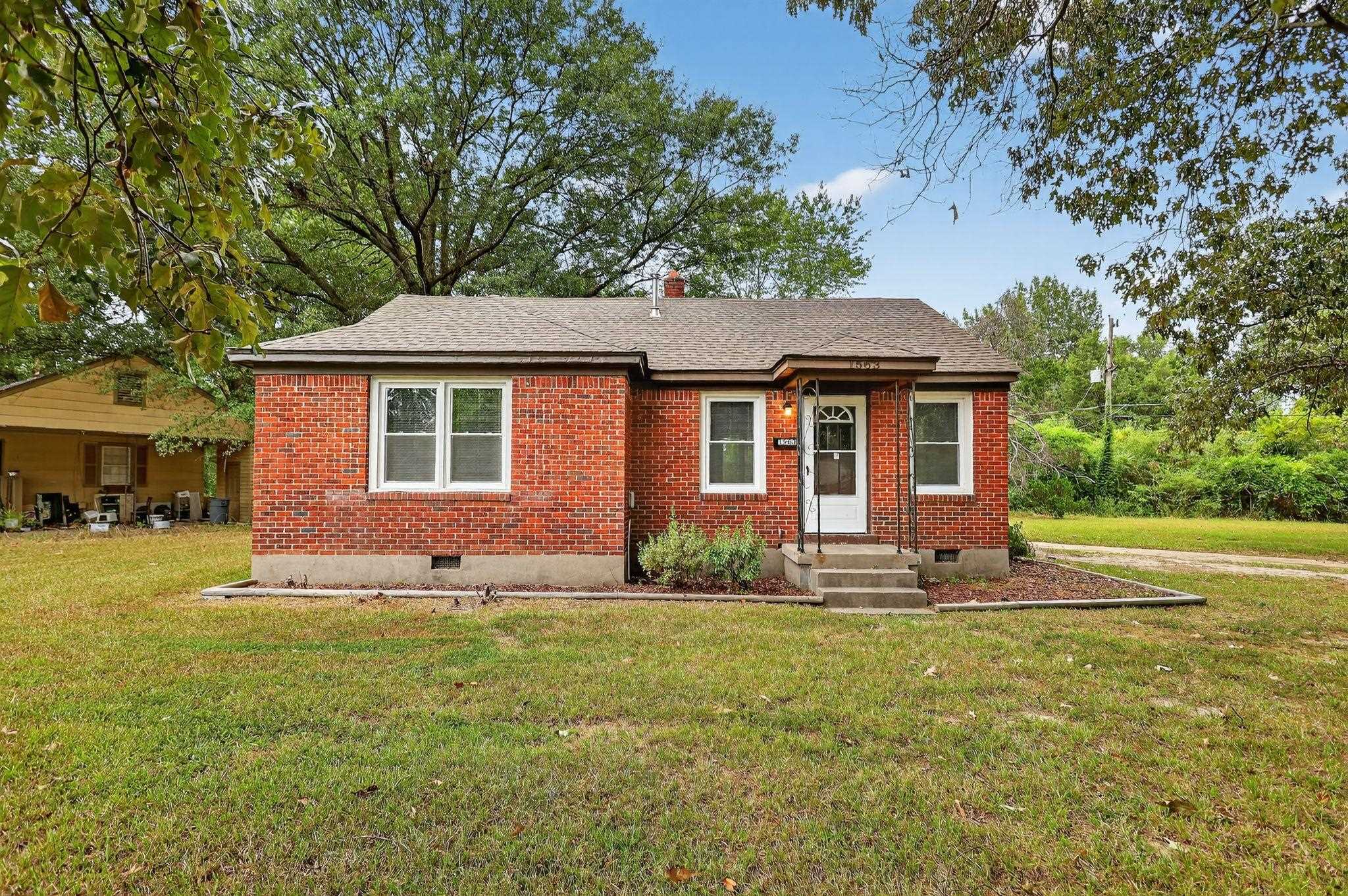 View of front of house featuring crawl space, brick siding, a front lawn, and roof with shingles