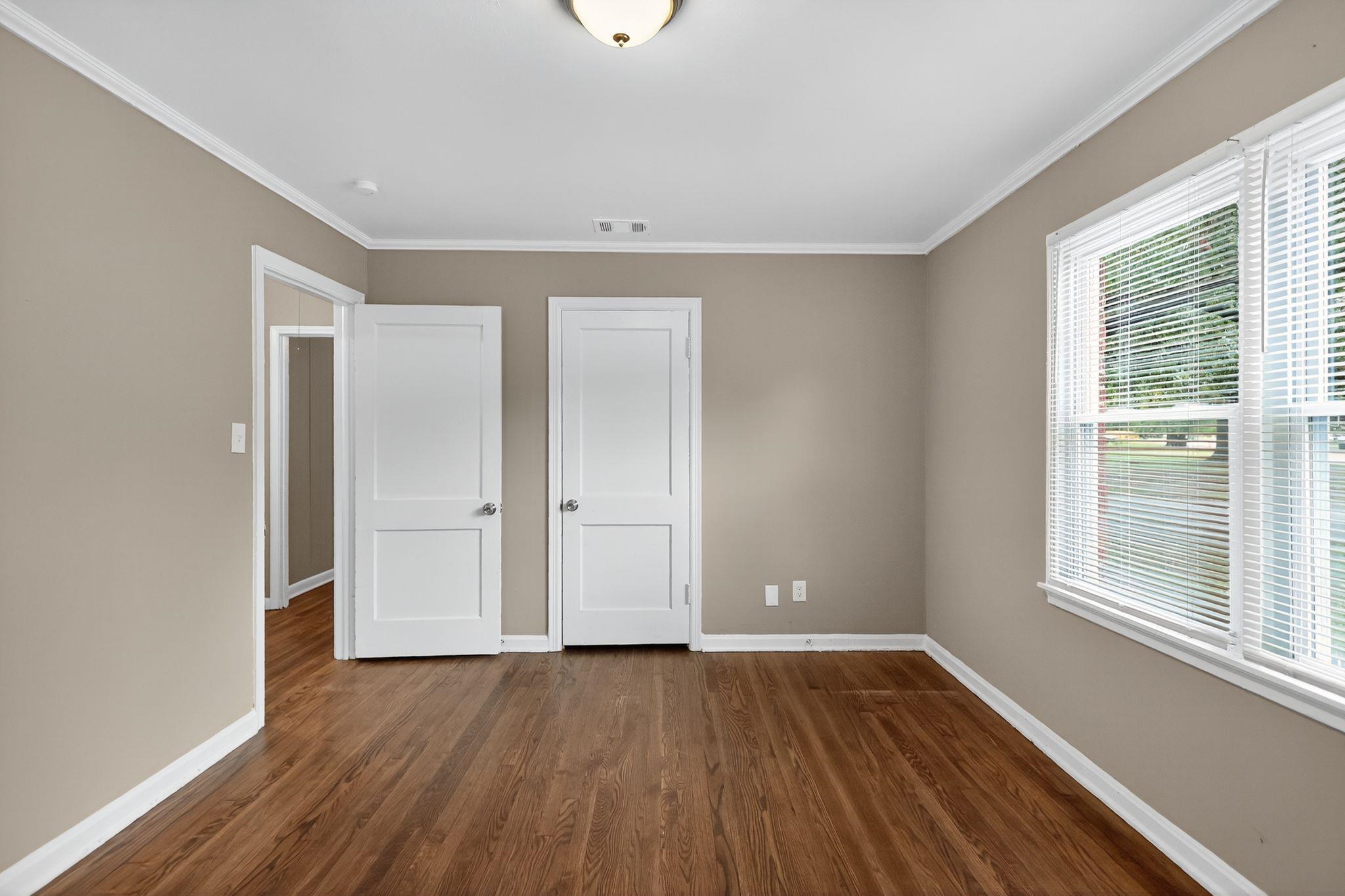 1563 Flamingo Road Memphis, TN 38117 - Photo 16 of 33 Unfurnished bedroom with dark wood-style floors, crown molding, and a closet