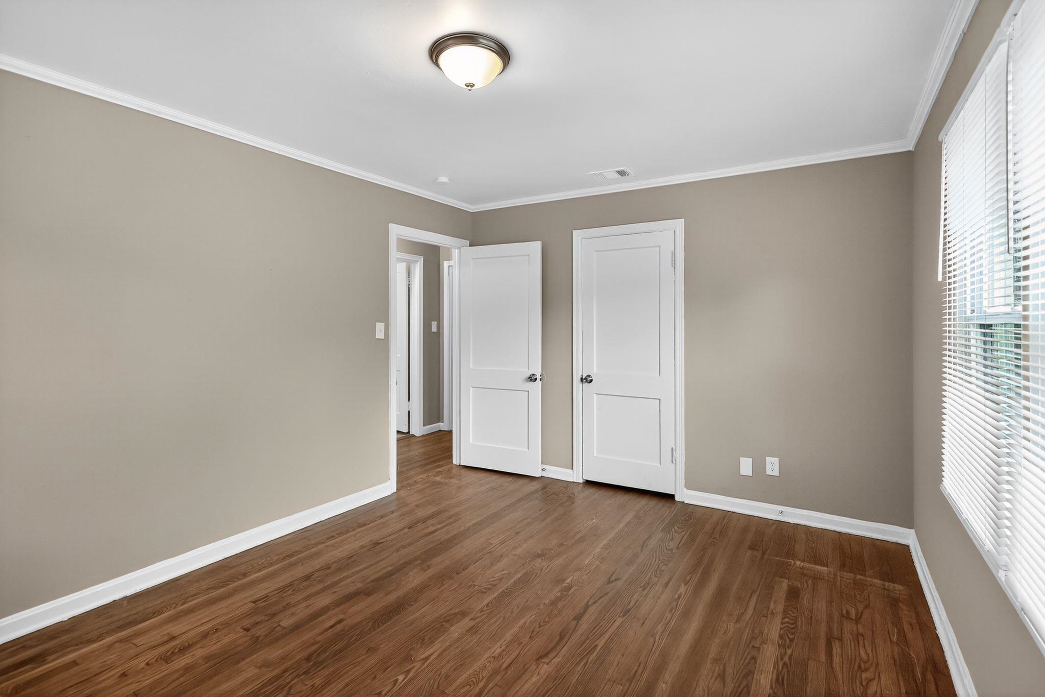 1563 Flamingo Road Memphis, TN 38117 - Photo 17 of 33 Unfurnished bedroom featuring ornamental molding, dark wood-style floors, and a closet