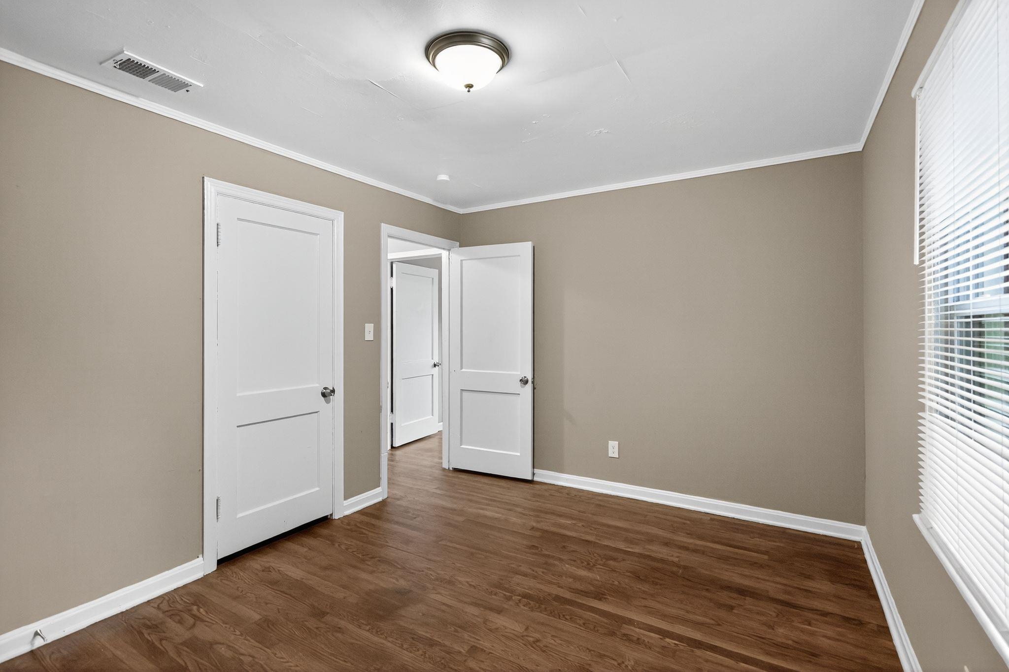 1563 Flamingo Road Memphis, TN 38117 - Photo 18 of 33 Unfurnished bedroom featuring crown molding and dark wood-style flooring