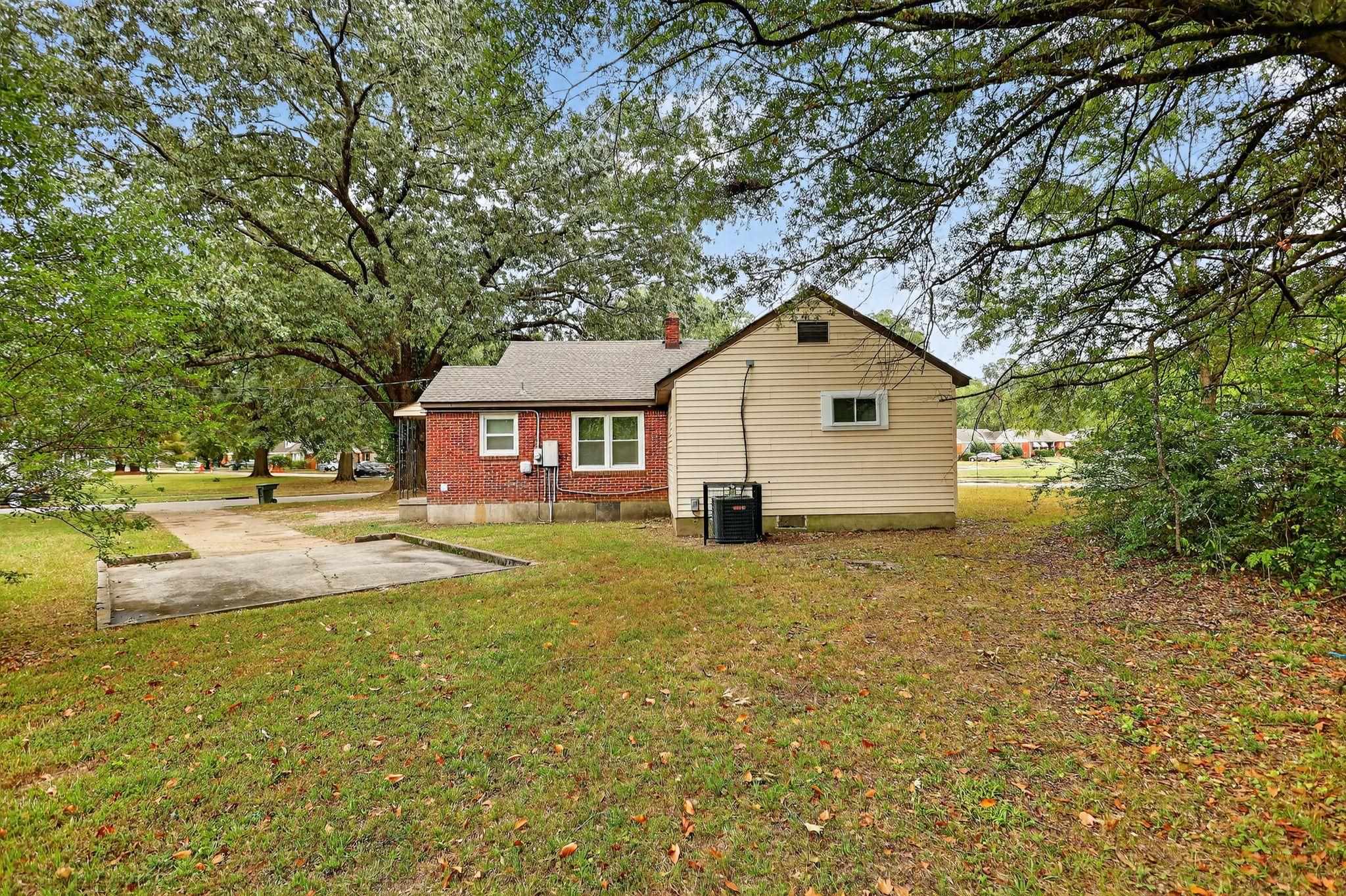 1563 Flamingo Road Memphis, TN 38117 - Photo 25 of 33 Back of property with a lawn, brick siding, a chimney, and a patio