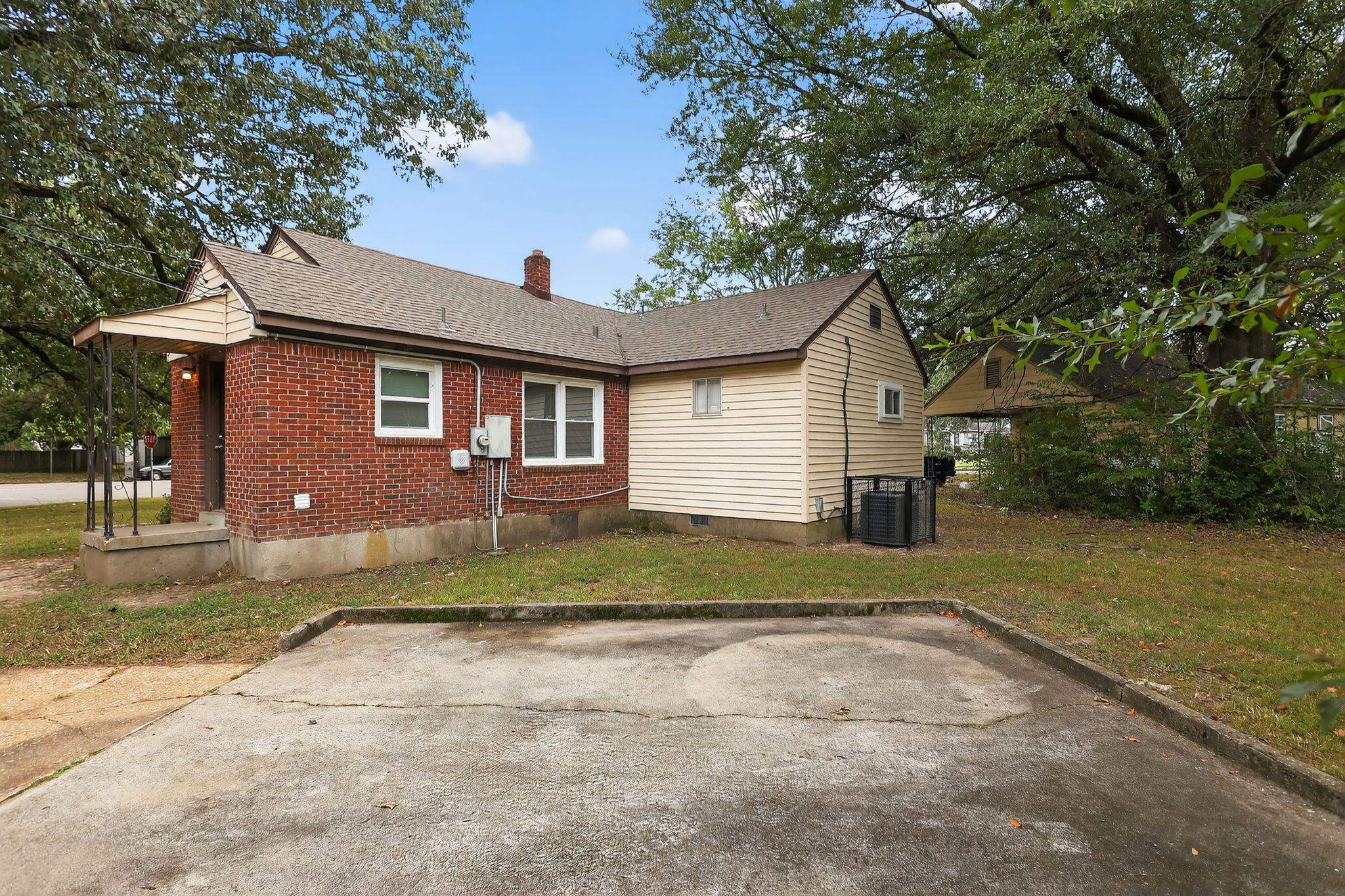 1563 Flamingo Road Memphis, TN 38117 - Photo 29 of 33 Back of house featuring a chimney, a shingled roof, brick siding, and a yard