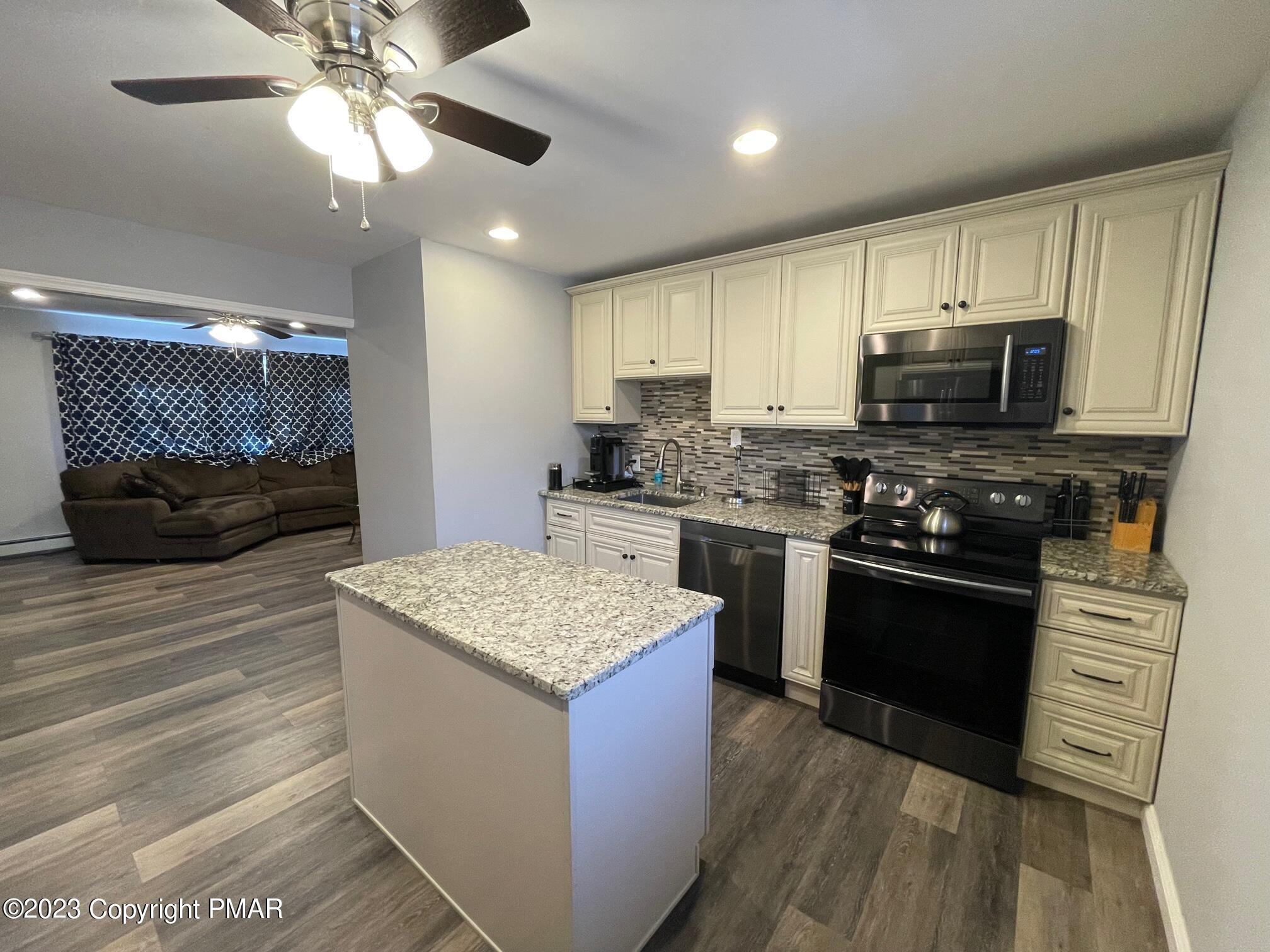 83 Fox Hill Road Albrightsville, PA 18210 - Photo 8 of 22 a kitchen with stainless steel appliances kitchen island granite countertop a stove a sink and a microwave