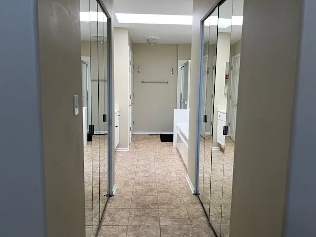 a view of a hallway with a livingroom and a bathroom with sink