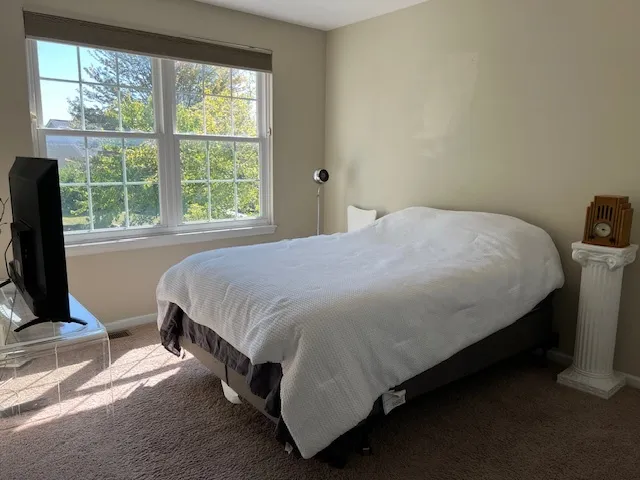a bed sitting in a bedroom next to a window