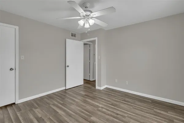 a view of an empty room with wooden floor