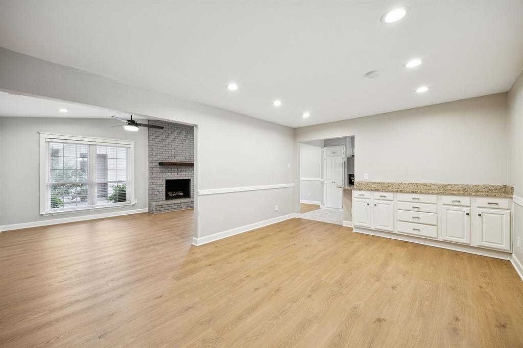 2015 Sandy Trail Richardson, TX 75080 - Photo 19 of 19 an empty room with wooden floor and a kitchen