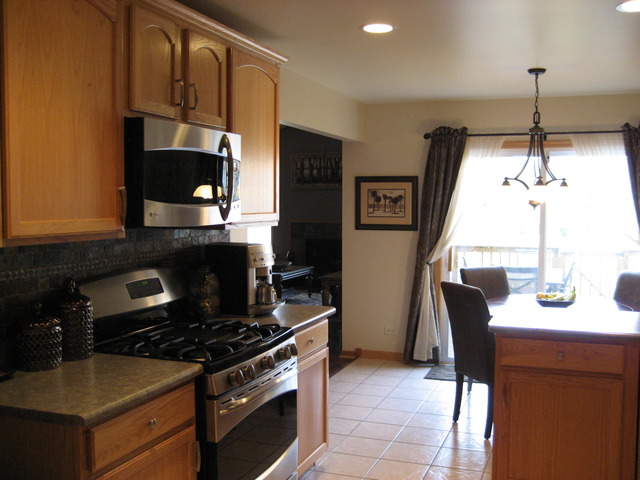 1444 Mackenzie Lane Elgin, IL 60120 - Photo 5 of 25 a kitchen with stainless steel appliances a stove a sink and a microwave