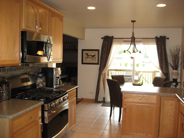 1444 Mackenzie Lane Elgin, IL 60120 - Photo 8 of 25 a kitchen with stainless steel appliances granite countertop a stove a sink and a microwave