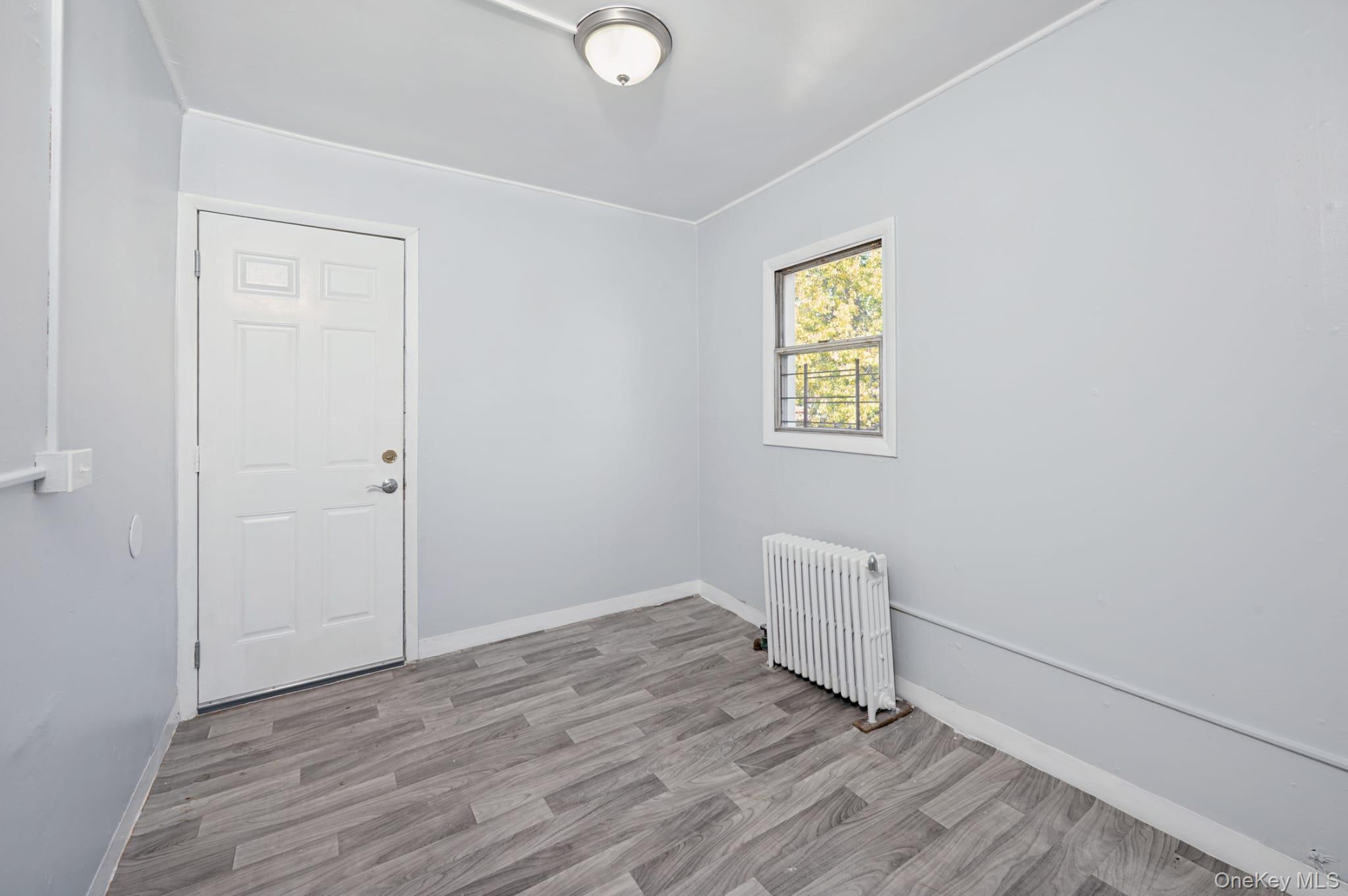 611 St Lawrence Avenue, Unit 1 Bronx, NY 10473 - Photo 14 of 20 a view of an empty room with wooden floor and a window