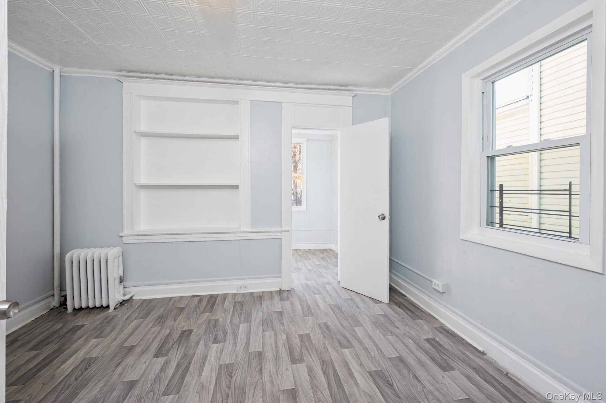 611 St Lawrence Avenue, Unit 1 Bronx, NY 10473 - Photo 16 of 20 an empty room with wooden floor and windows