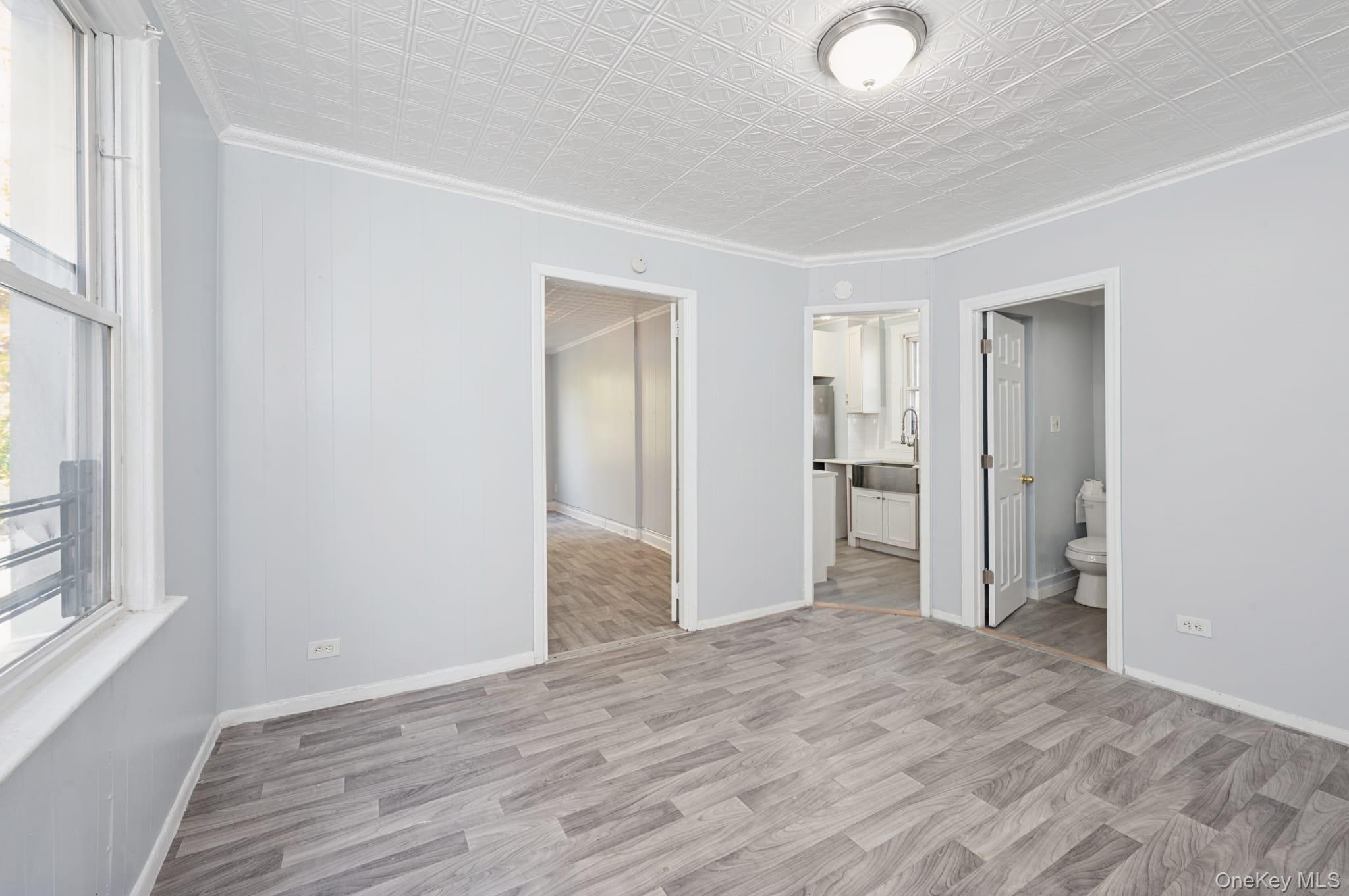 611 St Lawrence Avenue, Unit 1 Bronx, NY 10473 - Photo 19 of 20 a view of an empty room with wooden floor and a window