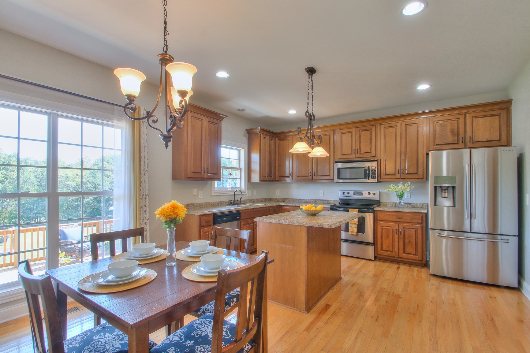 773 Sugar Flat Road Lebanon, TN 37087 - Photo 14 of 41 a kitchen with stainless steel appliances granite countertop a refrigerator a stove a sink dishwasher a dining table and chairs with wooden floor