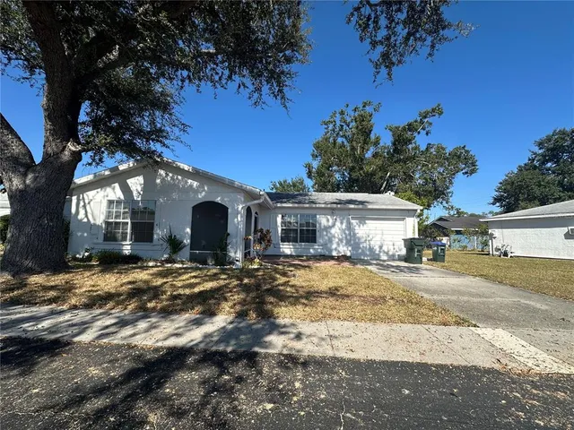 a view of a house with a yard and tree s
