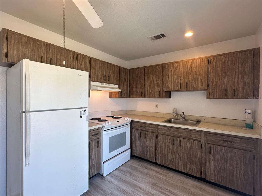 8100 Pickwick Road North Port, FL 34287 - Photo 15 of 15 a white refrigerator freezer sitting inside of a kitchen with stainless steel appliances granite countertop wooden cabinets a sink a stove a refrigerator and island