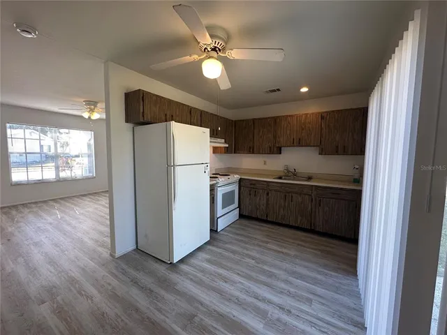 a kitchen with a refrigerator a sink and cabinets