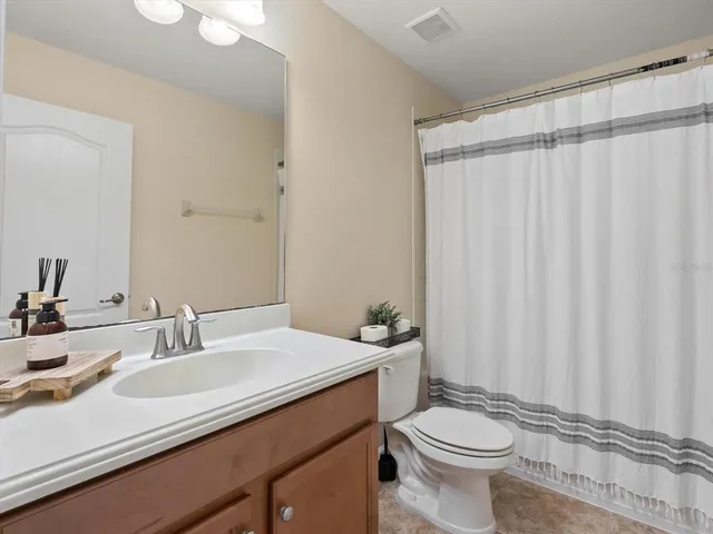 a bathroom with a sink a toilet and shower curtain