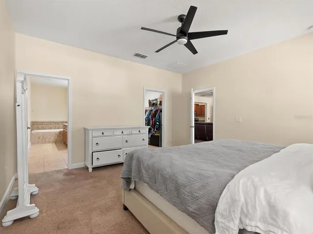 a bedroom with a large bed and a chandelier