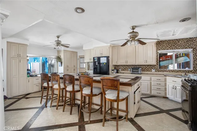a kitchen with a dining table chairs cabinets and stainless steel appliances