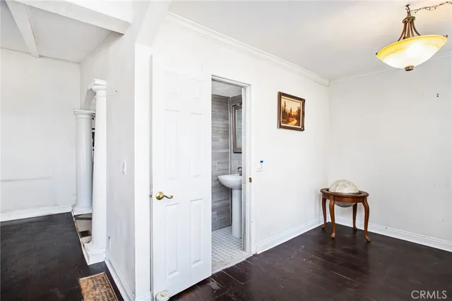 a view of a hallway with wooden floor and a cabinet