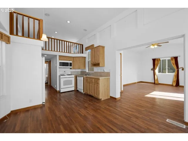 a kitchen with stainless steel appliances granite countertop a refrigerator a stove and a wooden floors