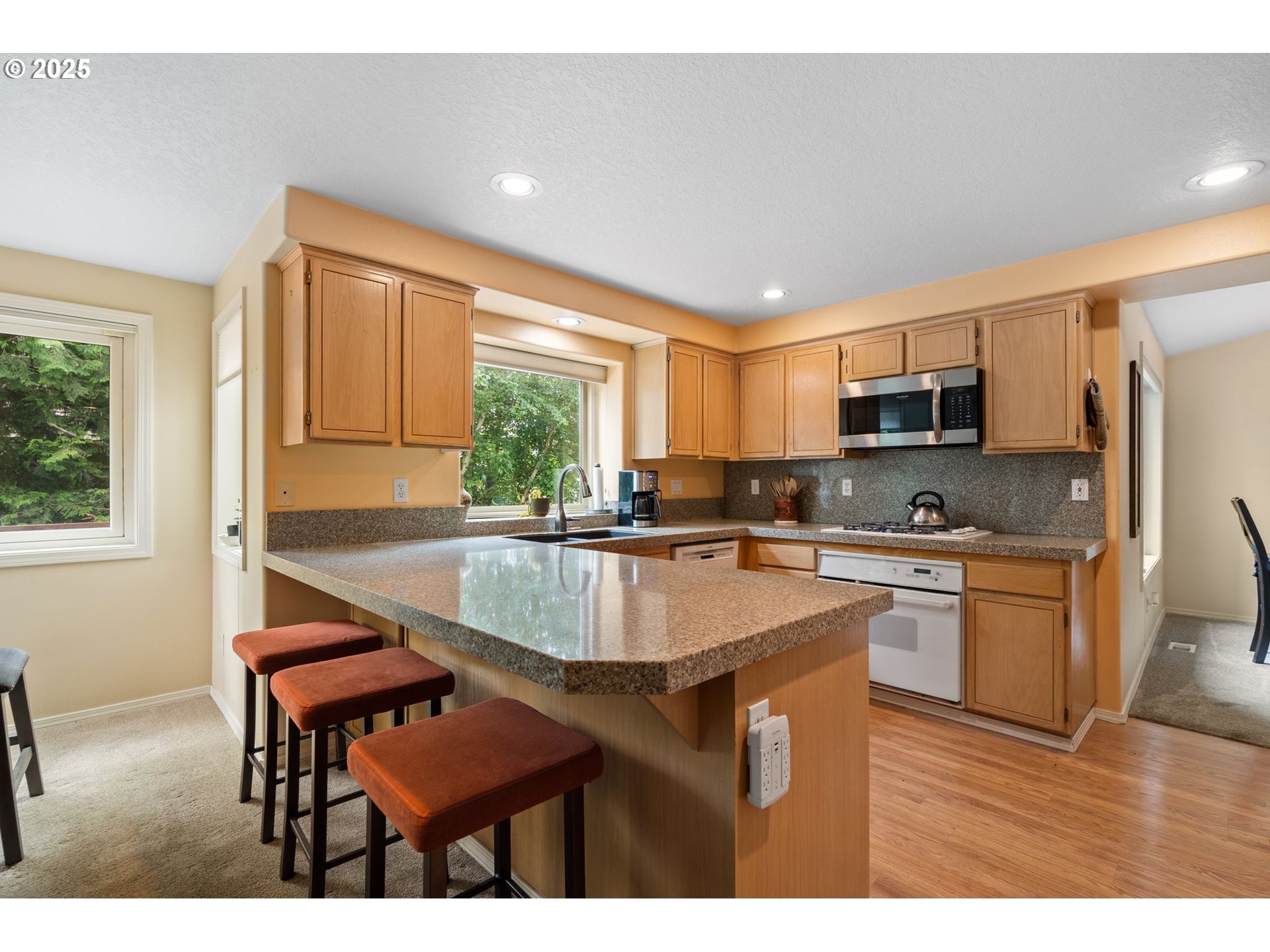 3010 Southwest Phyllis Drive Gresham, OR 97080 - Photo 11 of 48 a kitchen with stainless steel appliances granite countertop a sink a stove a refrigerator cabinets and a dining table