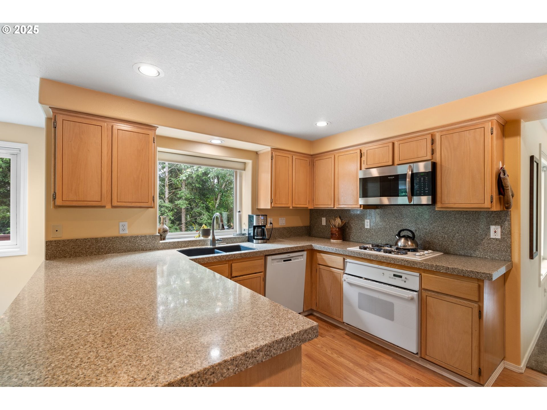 3010 Southwest Phyllis Drive Gresham, OR 97080 - Photo 10 of 48 a kitchen with stainless steel appliances granite countertop a stove a sink and a microwave