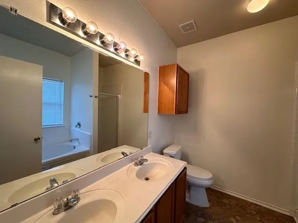 a bathroom with a sink a toilet and mirror