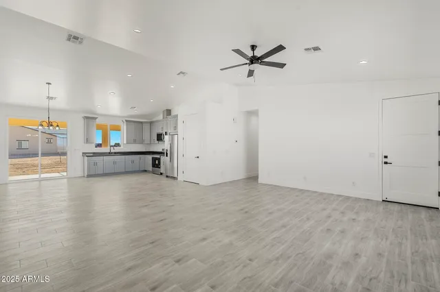 a large kitchen with a refrigerator a sink stainless steel appliances and cabinets