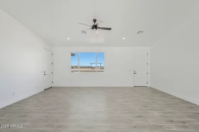 a kitchen with stainless steel appliances granite countertop a refrigerator a stove a sink and white cabinets with wooden floor