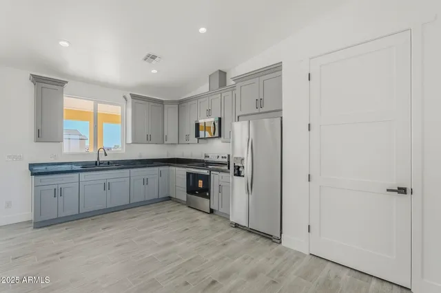 a kitchen with cabinets stainless steel appliances a sink and a window