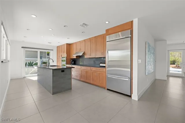 a kitchen with kitchen island granite countertop cabinets and refrigerator