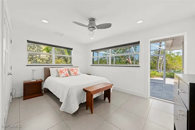 a bedroom with a bed and a dresser next to a window