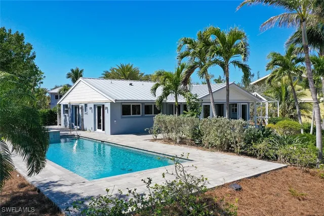front view of house with a yard and potted plants