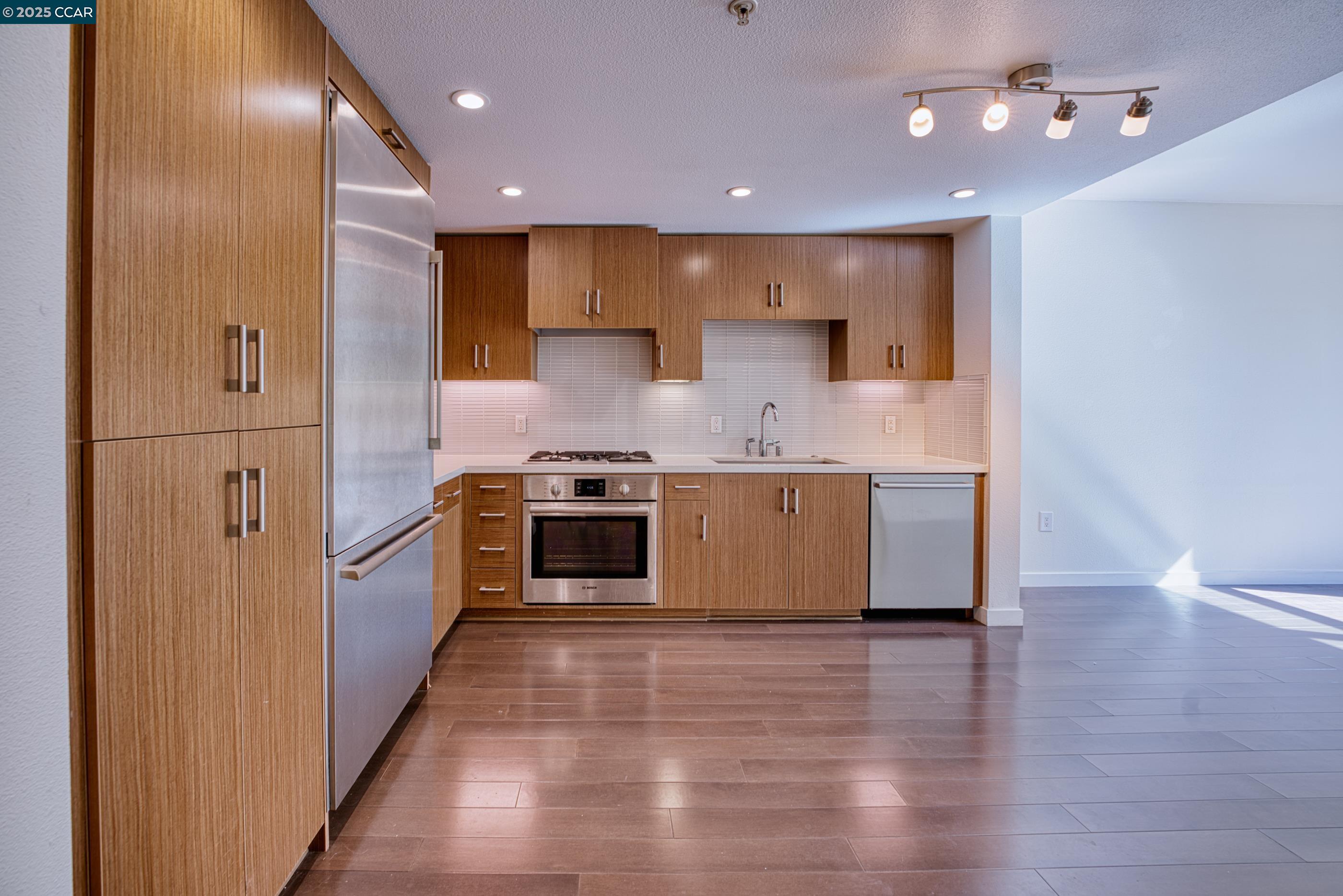 2655 Bush Street, Unit 110 San Francisco, CA 94115 - Photo 25 of 52 a large kitchen with stainless steel appliances granite countertop a stove and a refrigerator